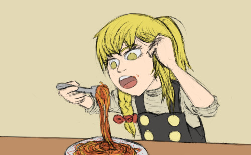 Marisa eating spaghetti. She is holding her hair away from the plate.